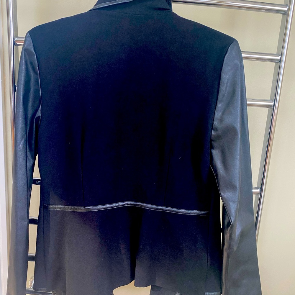 Black jacket with faux leather sleeves and trim.